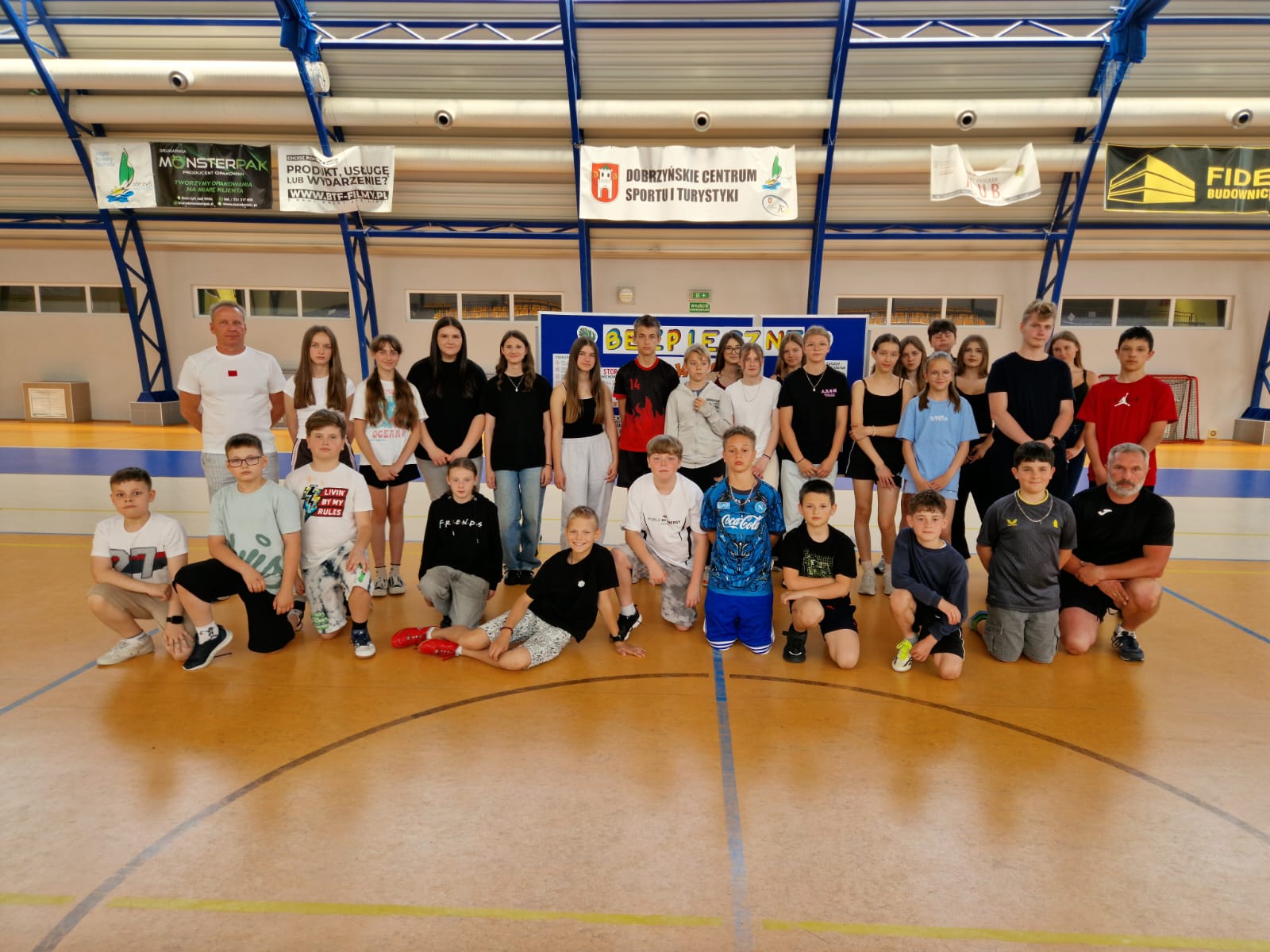 grupa uczniów z nauczycielami na hali sportowej
